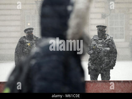 Polizisten sind im Einsatz am Buckingham Palace in London in den Schnee, als starker Schneefall ist die Straßen über Großbritannien am Dienstag morgen nach einigen Zentimetern in einigen Teilen im Laufe der Nacht fiel. Stockfoto