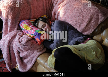 Eine müde Frau mittleren Alters schlafend auf einem Sofa. Stockfoto