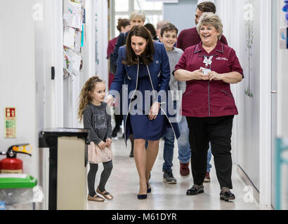 Die Herzogin von Cambridge ist durch fünf Jahre alte Bella Kedwell - Parsons durch einen Korridor der Kinder "Snow Leopard" Gemeinde led bei einem Besuch in St Thomas' Hospital, London, offiziell eine Kampagne Pflege weltweit zu fördern. Stockfoto