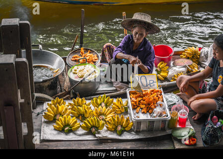 BANGKOK, THAILAND - 08 Oktober: Alte Frauen Händler gebraten gebratene Banane für verkaufen in das Boot in früheren Zeiten schwimmenden Markt am Oktober 08, 2017 in Bangkok. Stockfoto