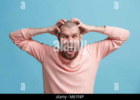Schöner Mann im Stress isoliert auf Blau Stockfoto