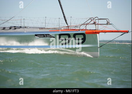 Der Hugo Boss 4 der Open 60-Klasse fuhr 2013 über den Solent. 2012 belegte die Yacht den 3. Platz beim Vendée Globe Race mit Alex Thomson als Skipper. Stockfoto