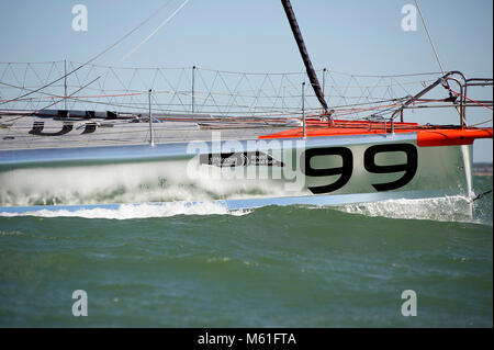 Der Hugo Boss 4 der Open 60-Klasse fuhr 2013 über den Solent. 2012 belegte die Yacht den 3. Platz beim Vendée Globe Race mit Alex Thomson als Skipper. Stockfoto