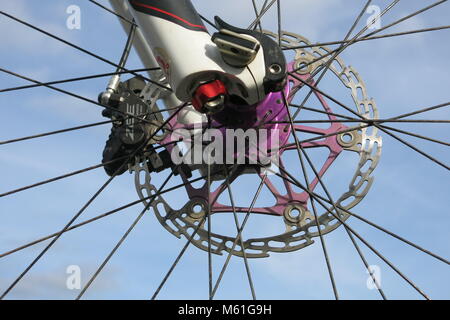 Detail der vorderen Nabe und Bremsscheibe eines Mountainbikes in enger vor einem strahlend blauen Himmel gezeigt Stockfoto