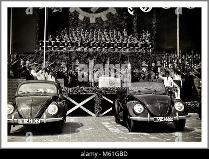 VOLKSWAGEN KdF-Wagen Start mit Adolf Hitler Nazi Deutschland Propagandabild 26. Mai 1938 Hakenkreuz Emblem Grundsteinlegung mit Adolf Hitler und Dr. Porsche und Beamte grüßen Heil Hitler im Volkswagen Werk Fallersleben Wolfsburg mit der bahnbrechenden neuen KdF - Wagen (Kraft durch Freude) Volkswagen Limousine und Cabriolet unter Nazi Hakenkreuz Fahnen Stockfoto