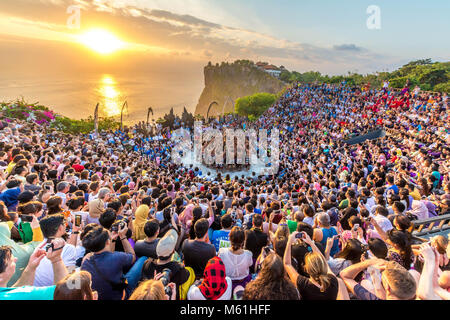 Touristen beobachten Sonnenuntergang mit traditioneller balinesischer Kecak Tanz in Uluwatu Tempel auf Bali, Indonesien. Stockfoto