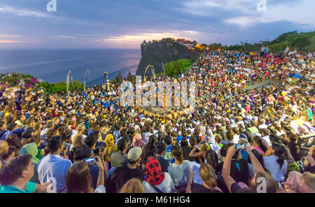 Touristen beobachten Sonnenuntergang mit traditioneller balinesischer Kecak Tanz in Uluwatu Tempel auf Bali, Indonesien. Stockfoto
