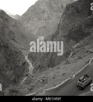 1950er Jahre, historische Bild, auf dem Gelände von Afghanistan, mit ihren tiefen Tälern, Schluchten und schroffe Berge, wie ein kleiner Bus fährt bis zum berühmten Grand Trunk Road über die Hindu Kush Gebirges Stockfoto