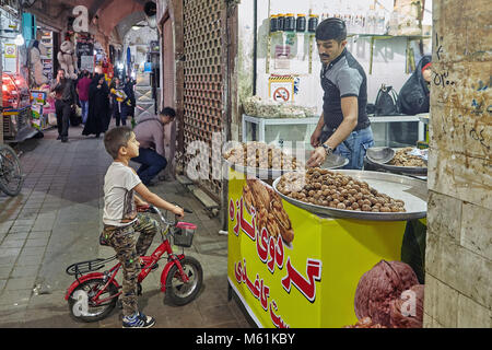 Kashan, Iran - 25. April 2017: iranischen Mann verkauft Backwaren auf einen Jungen auf einem Fahrrad in den östlichen Markt. Stockfoto