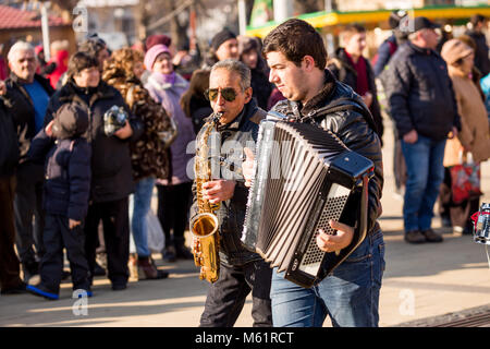 PERNIK, Bulgarien - 26. JANUAR 2018: Old Street Musiker mit weißem Haar und Sonnenbrille spielt Saxophon beim Gehen bei der jährlichen Internationalen Fest Stockfoto