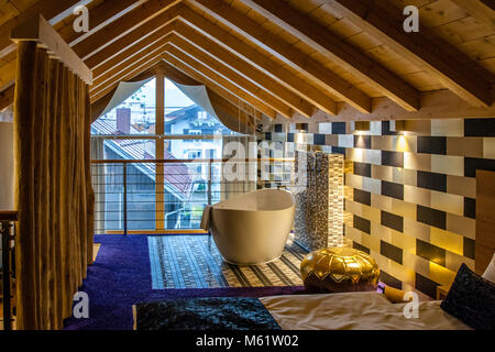 Möchten Sie ein Schaumbad in der freistehenden Panoramawanne? Die Giegelhöhe der Design-Suite beträgt übrigens 5 Meter. Badezimmer einer Suite im Hotel Freiberg, Oberstdorf, Deutschland Stockfoto