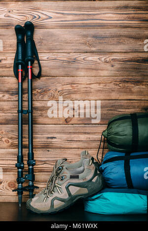 Trekking Schuhe, Schlafsäcke und Zelte auf hölzernen Stockfoto