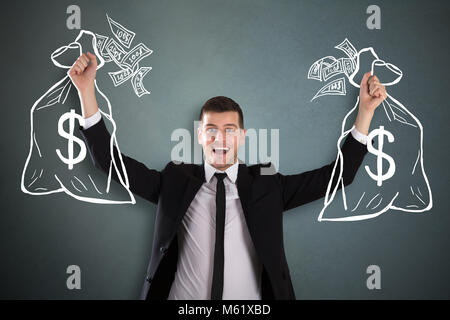 Junge glücklich Geschäftsmann Holding gezeichnet Geld beutel Skizze über Hintergrund Stockfoto