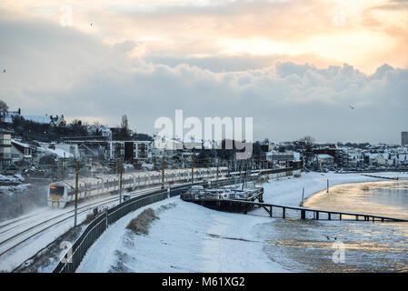 Zug im Schnee. C2C-Eisenbahn Zug durch den Schnee laufen fallenden Linien in Chalkwell in der Nähe von Southend-on-Sea, Essex. Tier aus dem Osten. Schnee am Strand Stockfoto