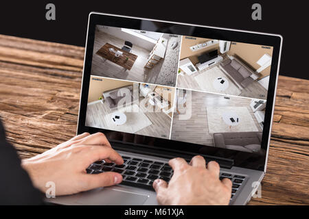 Nahaufnahme der Unternehmer bei der Kamera suchen, die auf Notebook am Schreibtisch Stockfoto