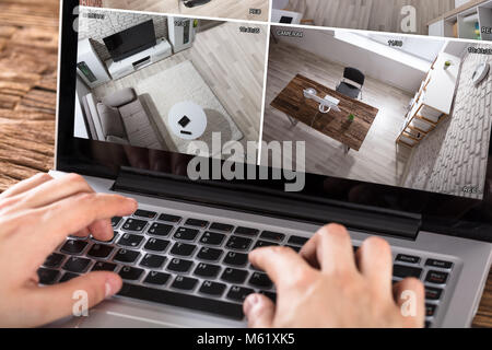 Nahaufnahme der Person Überprüfen der Sicherheit Kamera auf Laptop am Schreibtisch Stockfoto