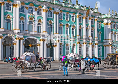 SAINT-Petersburg, Russland - 20. MÄRZ 2016: Personen, die sich in der Nähe Busse mit Pferden auf dem Schlossplatz. Auf dem Hintergrund ist die Eremitage Gebäude Stockfoto