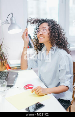 Weitwinkelaufnahme der verrückte Frau mit lockigem Haar. Wahnsinn während der Vorbereitung für die Prüfung Stockfoto