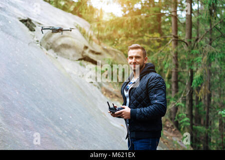 Guy startet einen quadrocopter im Wald Stockfoto