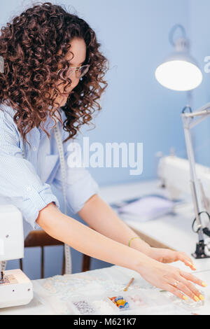 Frau Auswahl Perlen für die Dekoration Textilien in kurzwarengeschäften Studio Stockfoto