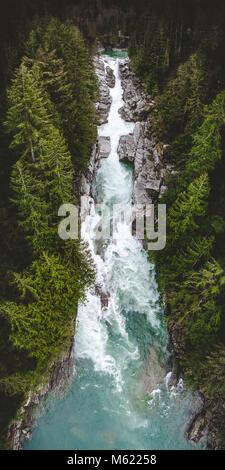 Groß natur Hubschrauber Drohne Portrait von wunderschönen türkisen Wasser des Flusses fließt durch Tight Long Canyon von hohen immergrünen Bäumen in Washi umgeben Stockfoto