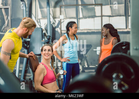 Seitenansicht eines stattlichen personal trainer Führen seiner Kunden im Fitnessstudio Stockfoto