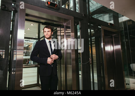 Im mittleren Alter Geschäftsmann mit Aktenkoffer aus Aufzug Stockfoto