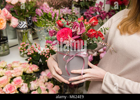 Frau, die Geschenkbox mit Blumen und lace Ribbon Stockfoto