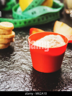Protein Pulver in Schaufel und Früchte auf steinernen Tisch Stockfoto
