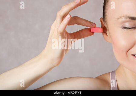 Junge Frau zwischen 30 und 35 Jahre alt ist die Einführung von Ohrstöpsel. Nahaufnahme. Stockfoto
