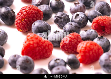 Himbeeren und Heidelbeeren auf weißem Hintergrund Stockfoto