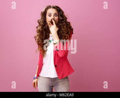 Rosa Stimmung. Überrascht, elegante Frau mit langen Welligen brünette Haare auf rosa Hintergrund, Schnurrbart von Haar Stockfoto