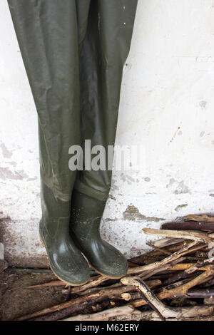 Brust wader Hosen fischer Stiefel über einem Haufen von Holz hängen Stockfoto