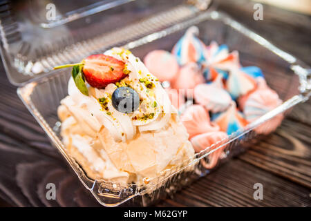 Scheibe der Swiss roll und bunten meringue Küsse Stockfoto