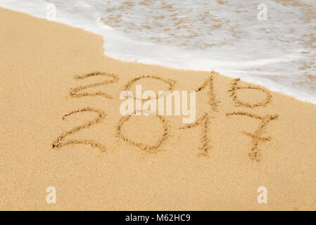 Ziffern 2016 und 2017 am Strand Sand - Begriff des neuen Jahres, Ferien-, Reise- und Lauf der Zeit. Stockfoto