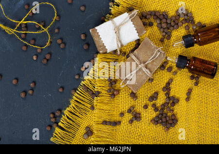 Cubeb Pfeffer Körner, Seife, und cubeb ätherisches Öl auf Holz Oberfläche. Ansicht von oben. Stockfoto