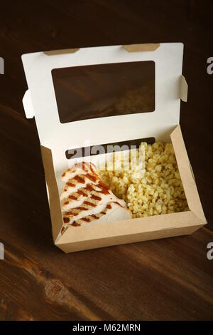 Gegrilltes Hähnchen mit Scheiben, mit Bulgur in einem Papier container. Lieferung nach Hause, einen schnellen Snack. Kalorienarme, diätetische Lebensmittel für einen gesunden Lebensstil. Stockfoto