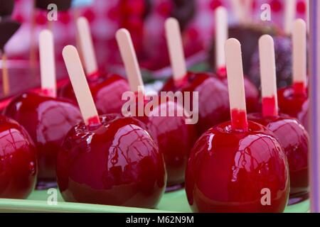 Süße glasierten Red candy Äpfel auf Stöcke für den Verkauf auf dem lokalen Markt. Kinder behandeln Konzept Stockfoto