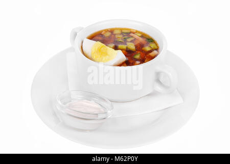 Okroshka mit Eier und saure Sahne. Auf eine Serviette in einer weißen Platte isolierten Weiß. Gerichte in einem Café, Restaurant, für ein Menü. Seitenansicht Stockfoto