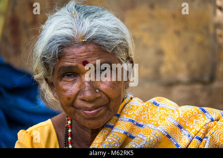 Porträt der ältesten indischen Dame mit traditionellen Bindi als drittes Auge, piercing auf Nase und trägt einen gelben Sari in Mysore, Karnataka, Indien Stockfoto
