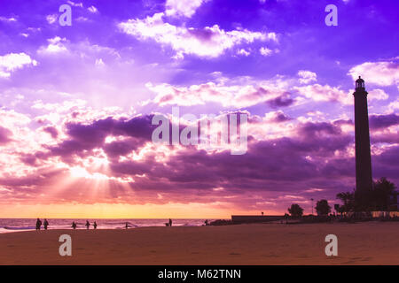 Die malerische Landschaft im Leuchtturm von Maspalomas mit bunten Sonnenuntergang und die Silhouetten, die laufen am Strand, Kanarische Inseln Stockfoto