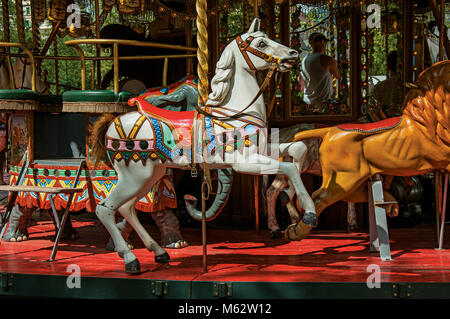 Buntes Karussell mit weißen Pferd in einem Park von Annecy. Eine historische und schöne Stadt am See am Departement Haute-Savoie, Frankreich. Stockfoto