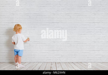 Baby Boy mit Pinsel zurück in der Nähe von Mauer Stockfoto