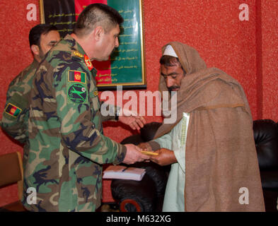 Der Vater eines afghanischen Commando Besuche mit Afghan National Army Special Operations Command Führung während ein Held Zeremonie am Lager Commando, Kabul, Afghanistan, 8. Februar, 2018. ANASOC lädt konsequent seine Helden und Familien Camp Commando. Bei der Begehung wurden die Verwundeten erhalten die richtige Pflege für ihre Verletzungen und die Familien sind für ihre große Opfer anerkannte Sicherheit und Stabilität für alle Afghanen zu verbessern. (U.S. Armee Stockfoto