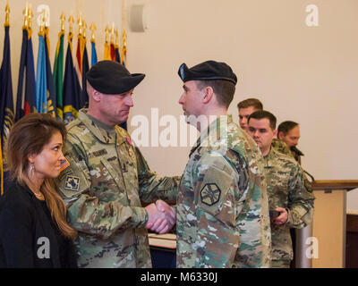 ANSBACH, Deutschland - ein Wechsel der Verantwortung Zeremonie für die US-Armee Garnison Ansbach (USAG Ansbach) Command Sergeant Major fand am 8. Februar 2018, in der von Steuben Community Center auf Bismarck Kaserne. Die ausgehende Command Sergeant Major Derek R. Cuvellier die Farben aufgegeben, was bedeutet, dass die Übertragung der Verantwortung auf eingehende Command Sergeant Major Philson Tavernier. Nach der Übertragung der Farben, eine Pensionierung Zeremonie war für Cuvellier, worin er Auszeichnungen für Service erhalten. Ein Empfang anschließt. USAG Ansbach Kommandant Oberst Benjamin C. Jones führte die Zeremonie Stockfoto