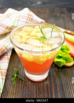 Limonade mit Rhabarber und Rosmarin in einem Glas, Stiele und ein Blatt eines pflanzlichen, Serviette auf einem Hintergrund von dunklem Holz board Stockfoto
