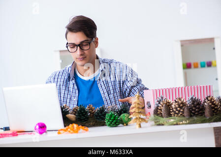 Junger Mann, der weihnachtsdekoration von Kegel Stockfoto