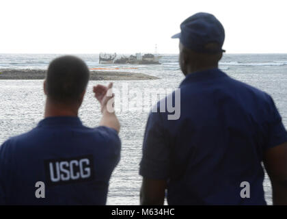 Cmdr. Ulysses Mullins, Stellvertretender Sektor Kommandant Küstenwache Sektor Honolulu, und Chief Warrant Officer Bryan Anderson Küstenwache Sektor Honolulu Prävention, künftige Operationen für die Beseitigung der Ware an Bord der 88-Fuß-kommerziellen Fischereifahrzeug Chui Zai Fa Nr. 1 geerdet über 300 Yards weg Leone Bay, Amerikanisch-Samoa, Feb.11, 2018 diskutieren. Der Eigentümer der Chui Zai Fa Nr. 1, ist die verantwortliche Partei ist und arbeiten aktiv mit Coast Guard Beamten und örtlichen Behörden eine bergungsmannschaft Plan für den geerdeten Fischereifahrzeug zu entwickeln. (U.S. Küstenwache Stockfoto