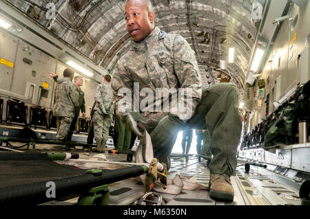 Us Air Force Tech. Sgt. Reginald Bonapart, einem aeromedical Rettungssanitäter mit der 156 Aeromedical Evacuation (AE) Geschwader von Charlotte, North Carolina, sichert die Würfe auf den Boden einer C-17 Globemaster in der Vorbereitung für das Training PATRIOT South 18 an der CRTC Gulfport in Gulfport, Fräulein am 12.02.2018. PATRIOT South 18 ist eine gemeinsame - Agentur Übung konzentriert sich auf die Erhöhung der Fähigkeit der lokalen, staatlichen und föderalen Organisationen zu koordinieren zusammen arbeiten, in Reaktion auf eine natürliche oder vom Menschen verursachte Not- und. (Ohio Air National Guard Stockfoto