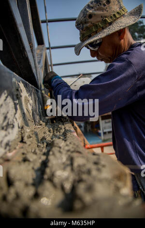 Royal Thai Navy Chief Petty Officer 1 Pairate Ruksawong, Construction Engineer Regiment, aus der Provinz Rayong, Thailand, gießt Beton während der Übung Cobra Gold 2018, Feb 7, 2018. Soldaten und Matrosen von der Royal Thai Navy, Singapur Armee und der US-Marine, arbeiteten zusammen, eine Mehrzweck-class Zimmer für das Wat Sombum Naram Schule in der Provinz Rayong, Thailand zu errichten. Cobra Gold 2018 unterhält konzentrieren sich auf humanitäre Civic action, Engagement für die Gemeinschaft und medizinischen Tätigkeiten während der Übung durchgeführt, um die Bedürfnisse und humanitären Interessen der Zivilbevölkerung in der Region zu unterstützen. Stockfoto